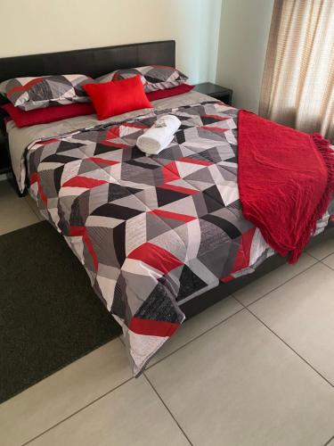 a bed with a colorful quilt on it in a bedroom at Greenstone Ridge Apartment in Johannesburg