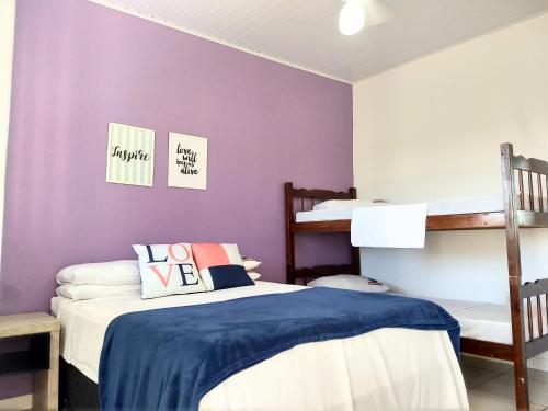 1 dormitorio con 2 literas y paredes moradas en Pousada No Farol en Tramandaí