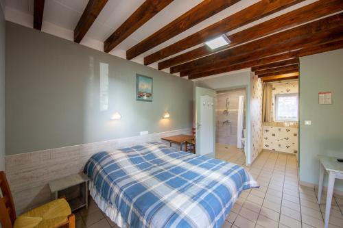 sypialnia z niebiesko-białym łóżkiem w pokoju w obiekcie Auberge du Tranchoir w mieście Nevoy