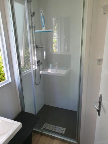 La salle de bains est pourvue d'une douche et d'un lavabo. dans l'établissement MOBIL-HOME OHARA 2020, à Biscarrosse
