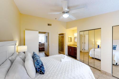 una camera con letto bianco e ventilatore a soffitto di Mangrove Oasis a Holmes Beach