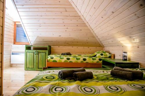 two beds in a room with wooden walls at Vikendica Martinovic in Zlatibor