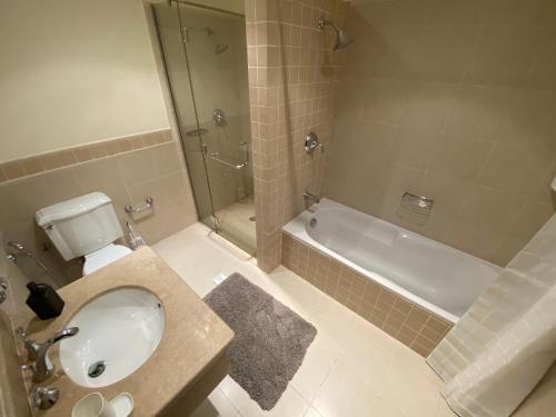 een badkamer met een toilet, een wastafel en een bad bij مسكن الشاطئ Beach House in King Abdullah Economic City