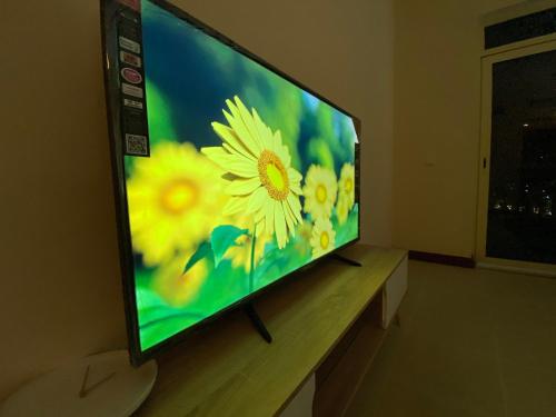 a television screen with a picture of yellow flowers at مسكن الشاطئ Beach House in King Abdullah Economic City