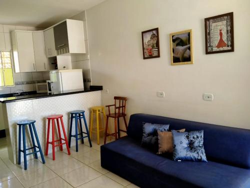 a living room with a blue couch and a kitchen at Casa Guaratuba 3 quadras da praia. in Guaratuba