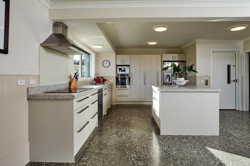 a large kitchen with white cabinets and granite counter tops at Kakatu Retreat Bed & Breakfast in Kaikoura