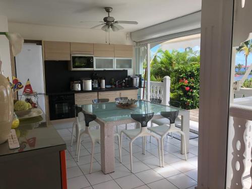 a kitchen with a table and chairs in a kitchen at Lauris - Résidence Savannah, 1 ou 2 Chambres avec cuve in Saint-François