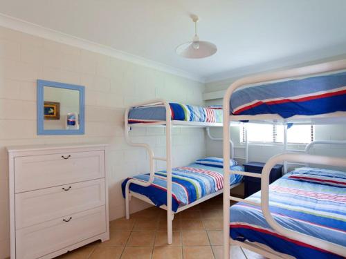 a bunk bed room with two bunk beds and a dresser at Blueys Beach Villa Manyana 24 in Blueys Beach
