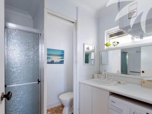 Baño blanco con lavabo y aseo en Blueys Beach Villa Manyana 26, en Blueys Beach
