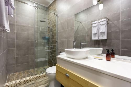 a bathroom with a sink and a toilet and a shower at IGMAR Apart Hotel in Tashkent