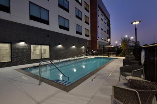 a swimming pool in front of a building at Holiday Inn Express & Suites Spring - Woodlands Area by IHG in Spring