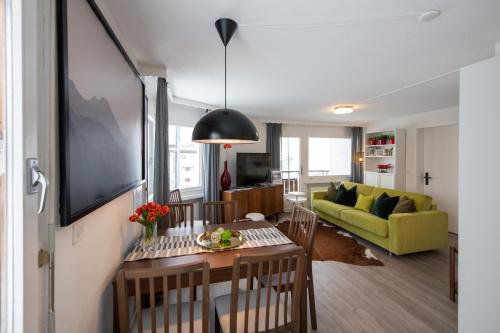 a living room with a table and a yellow couch at Agrimonia - möbilierte Ferienwohnung mit Balkon in Davos