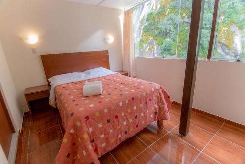 a bedroom with a bed and a large window at Casa Machu Picchu Hostel in Machu Picchu