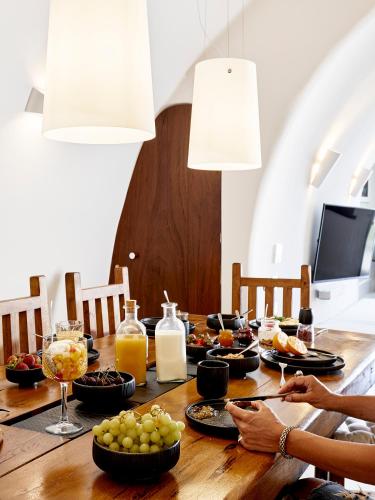 a dining room table with food on it at Luxury Villa Blue Dome Santorini in Imerovigli
