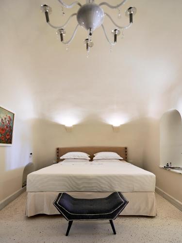 a bedroom with a large bed and a chandelier at Luxury Villa Blue Dome Santorini in Imerovigli