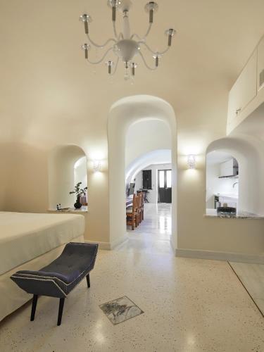 a large room with a bed and a chandelier at Luxury Villa Blue Dome Santorini in Imerovigli