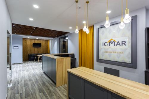 an office lobby with a table and a sign on the wall at IGMAR Apart Hotel in Tashkent