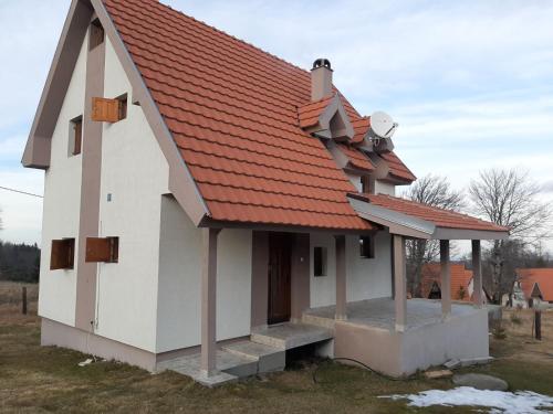a small white house with an orange roof at Golija Vikend kuća Milenković in Raška