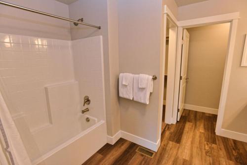 a bathroom with a tub and a shower with white towels at 103 Broken Pine by Casago McCall - Donerightmanagement in McCall