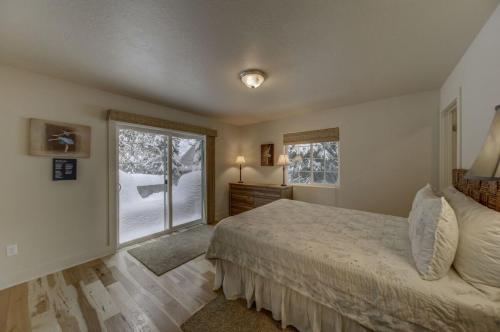 een slaapkamer met een bed en een groot raam bij Hubbard Cabin by Casago McCall - Donerightmanagement in McCall