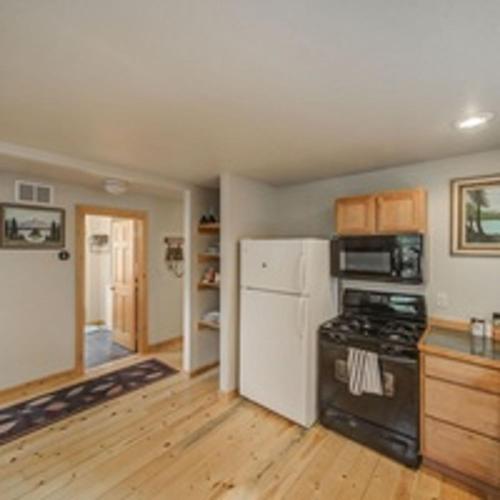 a kitchen with a stove and a refrigerator at Cascade Log Cabin by Casago McCall - Donerightmanagement in Cascade