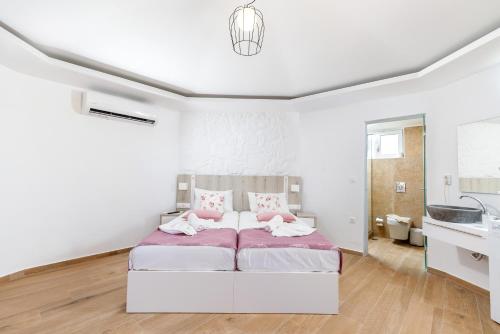 a white bedroom with a bed and a sink at Georgioupoli Studios in Georgioupolis