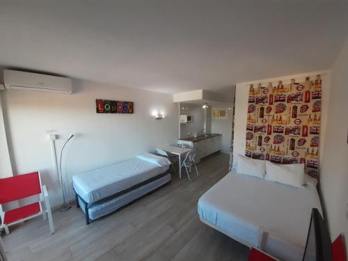 ベナルマデナにあるJupiter Apartments Sea Viewのベッド2台とデスクが備わるホテルルームです。