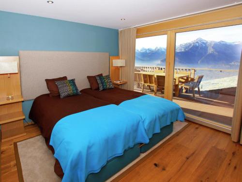 a bedroom with a bed and a view of the mountains at Inviting Holiday Home in Saint-Savinien with bubble bath in Veysonnaz