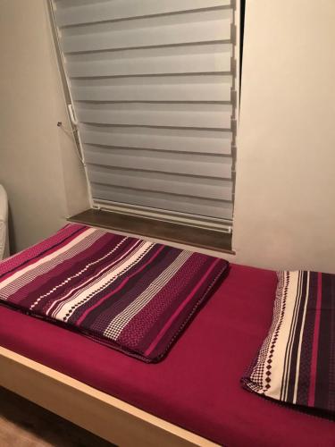 a bed with a window and a purple mattress at Tanie Pokoje Blisko Lotniska in Poznań