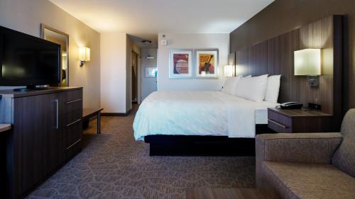 a hotel room with a bed and a flat screen tv at Holiday Inn Nashville - Vanderbilt - Dwtn by IHG in Nashville