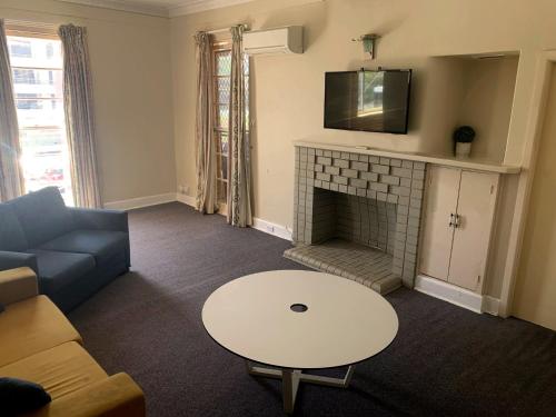 a living room with a couch and a fireplace at Port Macquarie Hotel in Port Macquarie