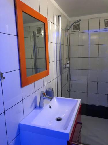 a bathroom with a sink and a mirror and a shower at Tanie Pokoje Blisko Lotniska in Poznań