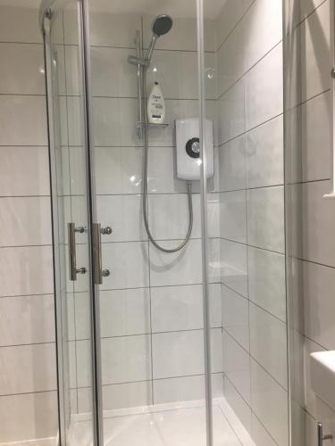 a shower in a bathroom with a glass door at Montague Villa in Dunoon