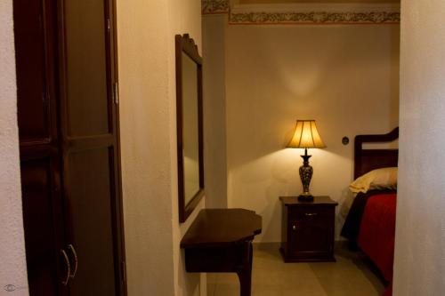 a bedroom with a bed and a lamp on a table at Cuartel 1914 - Hotel Boutique in Zacatecas