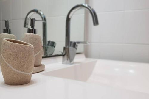 a kitchen counter with two sinks and two faucets at BANDOL Magnifique appartement en RDC cour sans vis à vis 5mn plage in Bandol