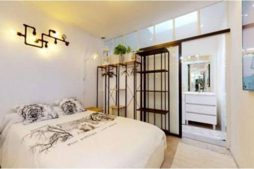 a bedroom with a large bed and a bathroom at BANDOL Magnifique appartement en RDC cour sans vis à vis 5mn plage in Bandol