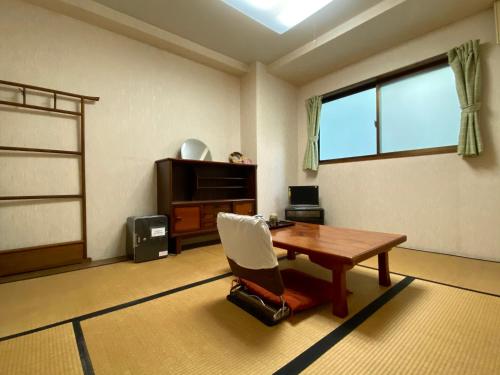 um quarto com uma mesa, uma cadeira e uma janela em Toyofuku em Kobe