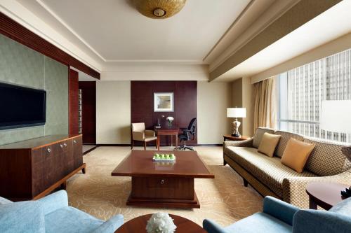 a living room with a couch and a television at Shangri-La Qingdao - May Fourth Square in Qingdao