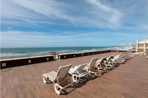 a row of chaise lounges on a pier with the ocean at Ocean Front- Marina View- Tiara Sands Resort, Sleeps 4 in Mazatlán