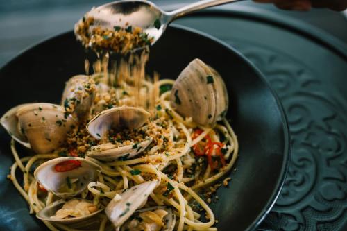 a bowl of pasta with seafood and a spoon at Bells at Killcare Boutique Hotel, Restaurant & Spa in Killcare