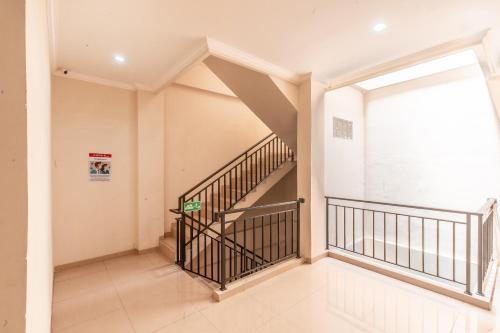 an empty hallway with stairs in a house at The Kartini 8 Residence - Mangga Besar in Jakarta