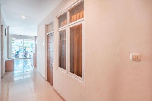 a hallway with a wall with windows and a door at The Kartini 8 Residence - Mangga Besar in Jakarta