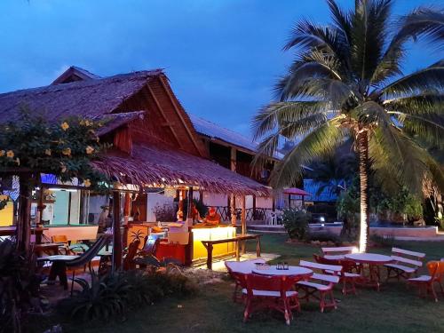 a resort with tables and chairs and a palm tree at Lam Sai village hotel Koh Yao Noi in Ko Yao Noi