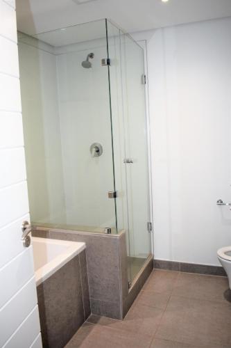 a bathroom with a glass shower and a toilet at Pebble Beach 304, Sibaya in Sibaya