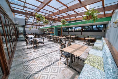 an empty restaurant with tables and chairs and windows at Southern Cross Hotel in Sydney