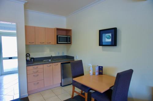 a kitchen with a wooden table and a dining room at Regal Palms Resort in Rotorua