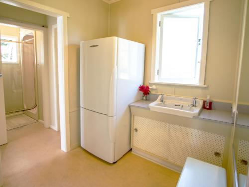 a white refrigerator in a kitchen with a sink at Incredible Bay Views - Kaiteriteri Bach in Kaiteriteri