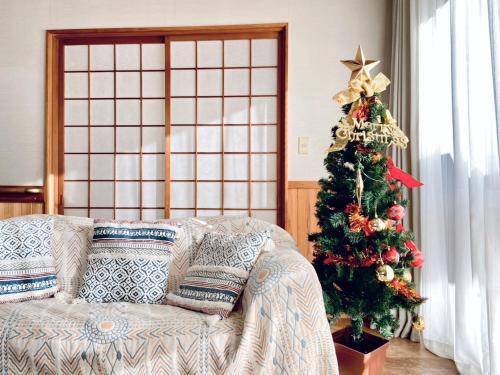 a living room with a christmas tree and a couch at 安野月江苑 Anno Gekkouen FUJI in Fujiyoshida