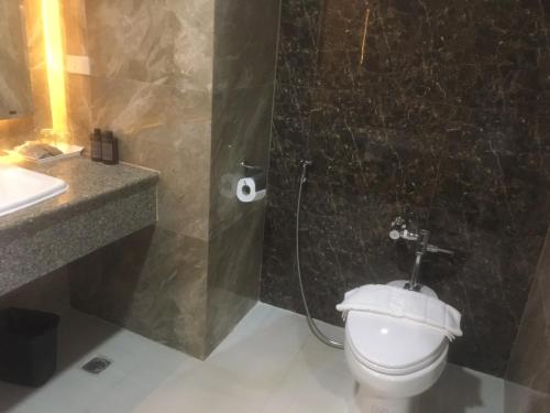 a bathroom with a toilet and a shower and a sink at Grandview Landmark Betong Hotel in Betong
