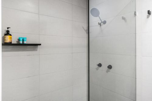 een badkamer met een douche met witte tegels bij Roses Byron in Byron Bay